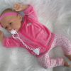 AD8c Levensechte Babypop Kristina soft body blauwe ogen met roze kleding en speen 52 cm